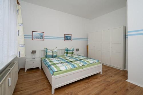 um quarto com uma cama e armários brancos em Villa Christiana - Jasmin em Graal-Müritz