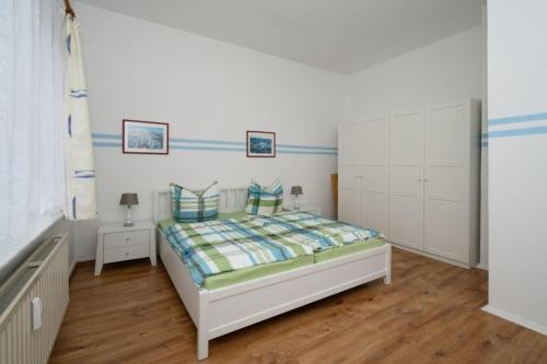 a bedroom with a bed and white cabinets at Villa Christiana - Jasmin in Graal-Müritz