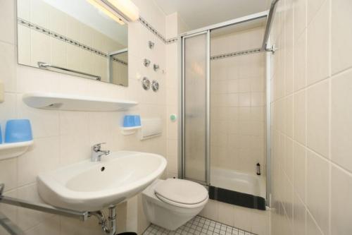 uma casa de banho com um WC, um lavatório e um chuveiro em Villa Christiana - Jasmin em Graal-Müritz