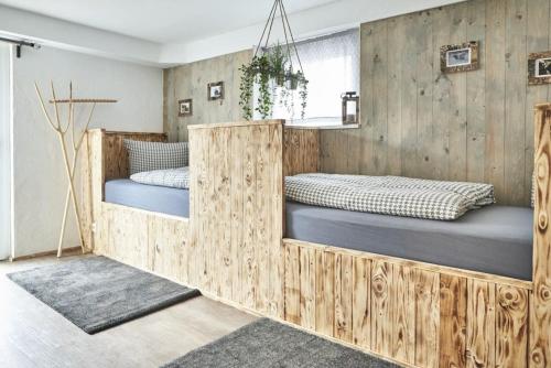 two beds in a room with wooden walls at Fewo Sonsenbach in Bad Berleburg