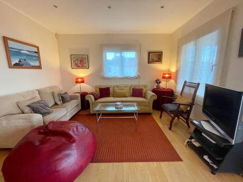 a living room with a couch and a red ottoman at Casa Varanda do Mar in Capelas