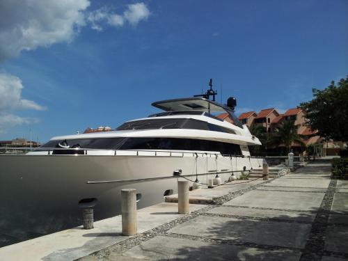 a large yacht is docked at a dock at Condo Bellmare in Puerto Aventuras