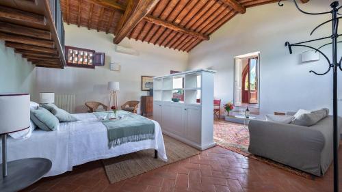 a bedroom with a bed and a couch in a room at Capanna di Citerna in Gaiole in Chianti