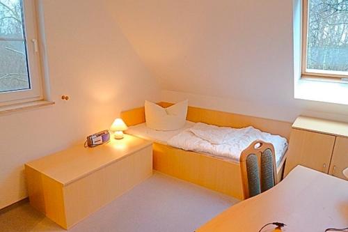 ツィングストにあるAm Deich 46のベッドと窓が備わる小さな客室です。