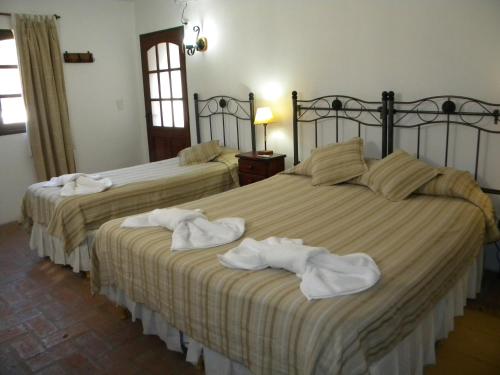 two beds in a hotel room with towels on them at Posada San Bras in Villa General Belgrano