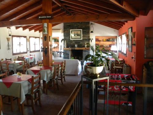 a restaurant with red walls and tables and chairs at Posada San Bras in Villa General Belgrano