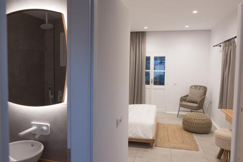 a bathroom with a bed and a sink and a mirror at Kantouni Blue Sea in Kalymnos