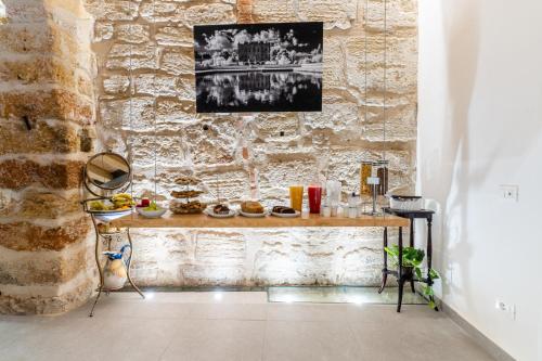 a table in a room with a stone wall at Khalisah in Palermo