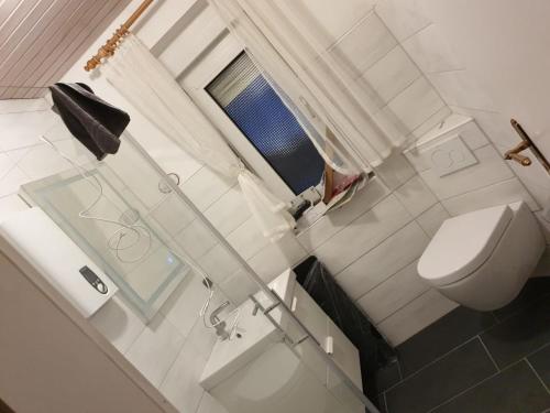 La salle de bains est pourvue de toilettes blanches et d'un lavabo. dans l'établissement Haus Michel, à Nordstrand