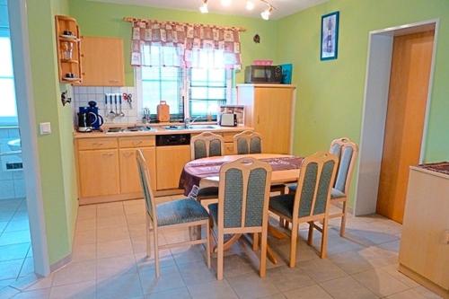 een keuken en eetkamer met een tafel en stoelen bij Am Deich 49 in Zingst