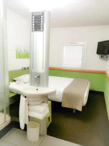 a bathroom with a sink and a toilet and a mirror at Ecomotel Grayston previously known as SUN1 Wynberg in Johannesburg