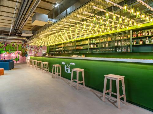 a green bar with stools in a room at JO&JOE Vienna in Vienna