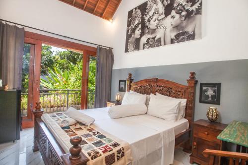 a bedroom with a bed and a balcony at Pondok Taksu Bali in Kuta