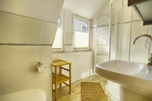 uma casa de banho branca com um lavatório e um WC em Haus Havelland em Zingst