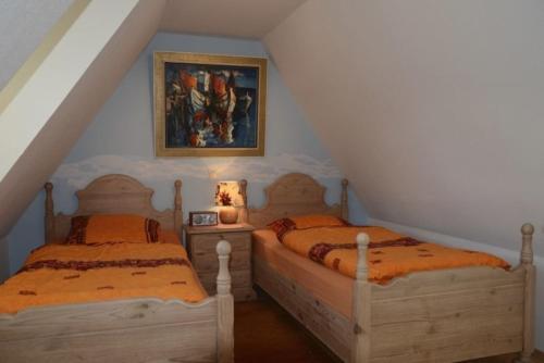 two twin beds in a attic room with a painting at Ferien unterm Reetdach Whg 03 in Oevenum