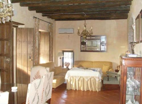 a living room with a table and a couch at Casa Rural El Chorrillo Cazalla de la Sierra in Cazalla de la Sierra