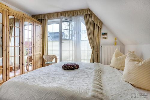 a bedroom with a large bed with a large window at Haus Seeschwalbe, FW 6 in Zingst