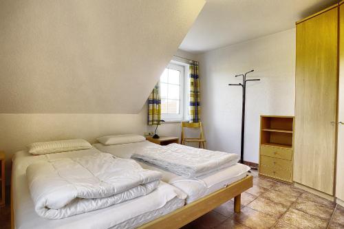 een slaapkamer met een bed en een kruis aan de muur bij Ostseehaus 2 in Zingst