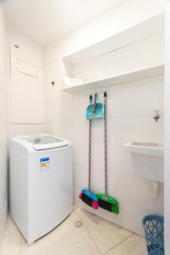 a bathroom with a washing machine and a sink at Aloha Residence in Porto De Galinhas