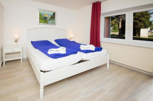 Rabenkirchen-FaulückにあるSchleiblick Sparzimmer 1のベッドルーム1室(白いベッド1台、青いシーツ付)、窓が備わります。