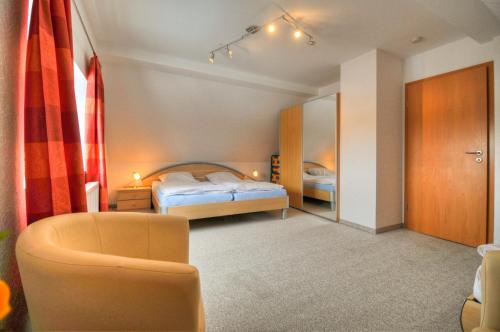 1 dormitorio con 1 cama y 1 silla en Ferienwohnung Sewald, en Wulfen auf Fehmarn