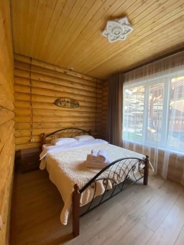 a bedroom with a bed in a wooden room at Eco hotel & restaurant "SKALA" in Borovoye