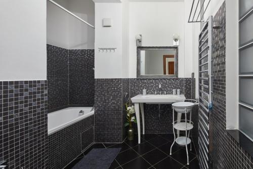 W łazience znajduje się umywalka, wanna i lustro. w obiekcie Lavish Apartment in Old Town by Prague Days w Pradze