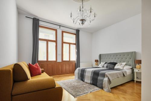 sypialnia z łóżkiem, krzesłem i żyrandolem w obiekcie Lavish Apartment in Old Town by Prague Days w Pradze