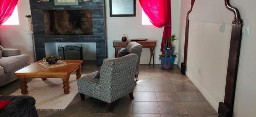 a living room with a couch and chairs and a fireplace at Bellamente Sirene in Gansbaai