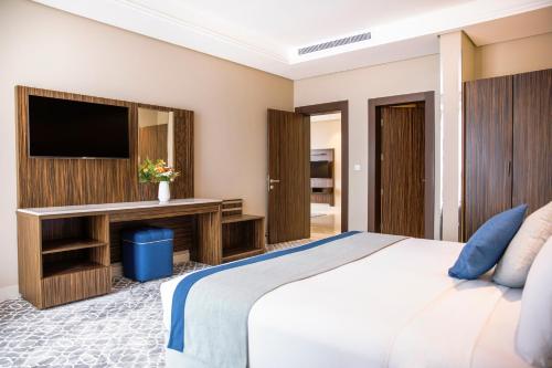 a bedroom with a large bed and a tv at Swiss Blue Hotel - Hera in Jeddah
