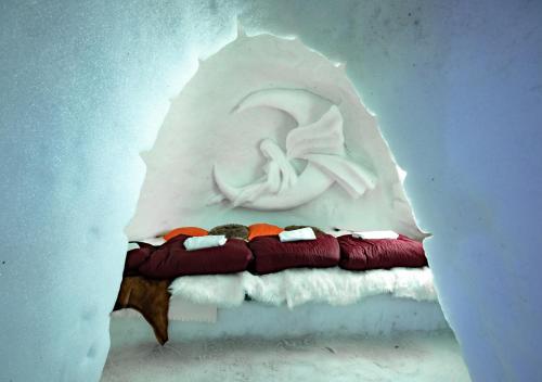 - un mur orné d'une sculpture d'un lit avec des oreillers dans l'établissement Village Igloo La Rosière, à La Rosière