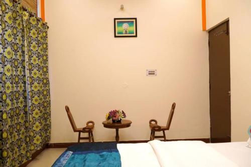 a bedroom with a bed and a table and chairs at SAI HOME in Dehradun