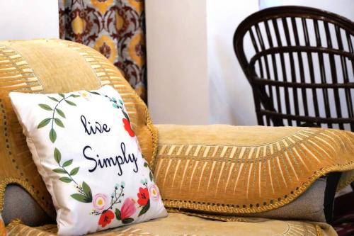 a pillow with the words live sundry on a couch at SAI HOME in Dehradun