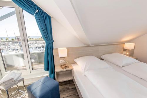 a hotel room with a bed and a window at ancora Marina Haus 1 Penthouse in Neustadt in Holstein