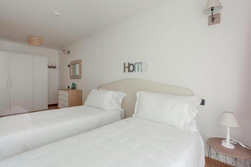 two beds in a room with white walls at Gressoney Saint-Jean apartments by Halldis in Gressoney-Saint-Jean