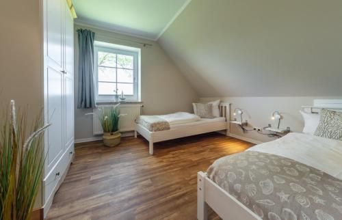 - une chambre mansardée avec un lit et une fenêtre dans l'établissement "Ferienhof Seelust" Ferienwohnung 5, à Gammendorf