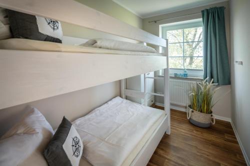 a bedroom with two bunk beds and a window at "Ferienhof Seelust" Ferienwohnung 5 in Gammendorf