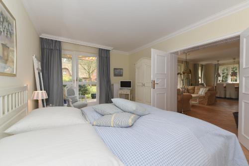 - une chambre avec un lit blanc et un salon dans l'établissement Gmelinstrasse 27, à Südstrand