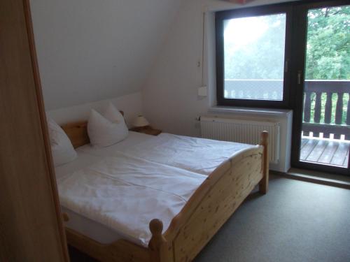 a bedroom with a bed and a large window at Finnhäuser am Vogelpark - Haus Brizi in Marlow