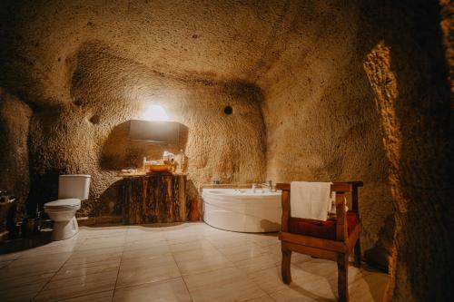 Baño de estilo cueva con bañera y aseo en Helios Cave Kapadokya, en Ürgüp