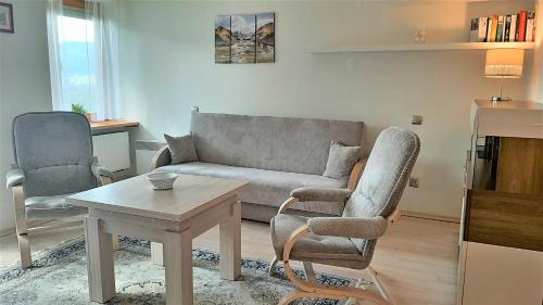 a living room with a couch and two chairs and a table at Apartament Peter Apartzakop in Zakopane