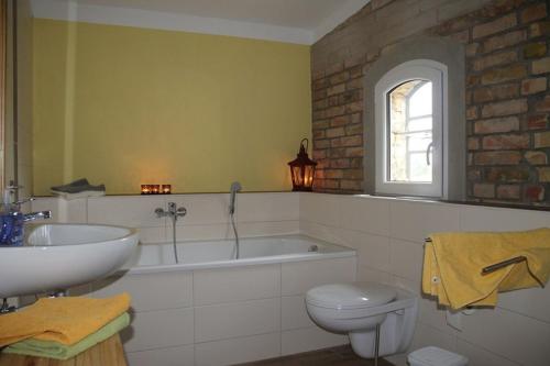 a bathroom with a sink and a tub and a toilet at Ferienhaus "Am Lindenhof" in Allerstorf