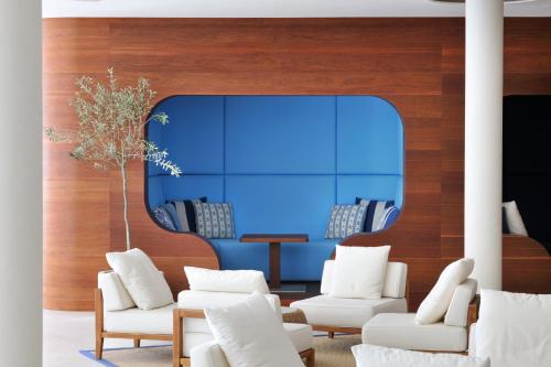 a room with white chairs and a blue wall at Falkensteiner Hotel & Spa Iadera in Zadar