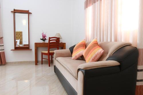 a living room with a couch with pillows on it at Hotel Nilketha Yala Tissamaharama in Tissamaharama