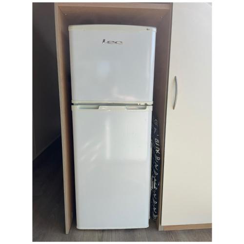 a white refrigerator in a box next to a wall at Caravan - sleeps 6 & parking in Hollington