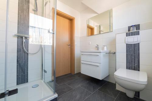 a bathroom with a shower and a toilet and a sink at Hoppenberg 5a in Zingst
