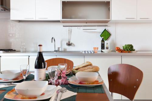 a kitchen with a table with a bottle of wine and bread at Granito's in Monte Petrosu