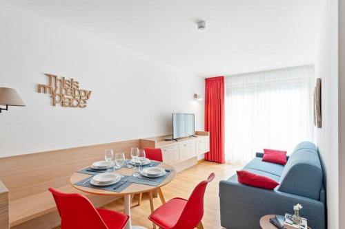 a living room with a table and red chairs at Gressoney Saint-Jean apartments by Halldis in Gressoney-Saint-Jean