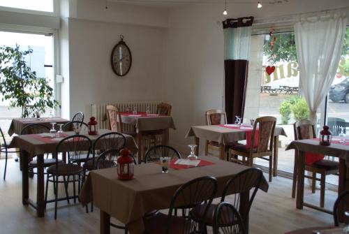 un restaurant avec des tables et des chaises et une horloge sur le mur dans l'établissement Hotel de Got, à Villandraut