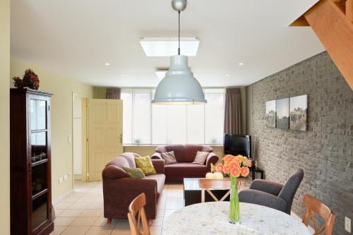 ein Wohnzimmer mit einem Sofa und einem Tisch in der Unterkunft Pieters Huis in Kinrooi